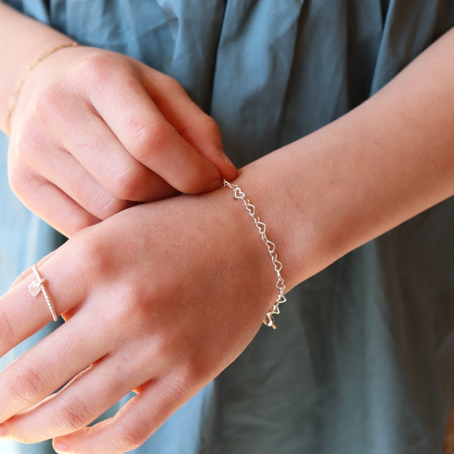 925 sterling silver heart link chain in children's sizes, photographed on a young girl's wrist