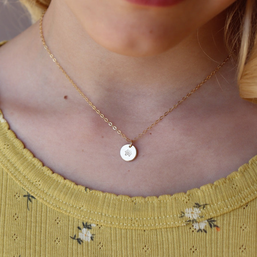 Model wearing Tiny Birth Flower Disc Necklace in 14k gold fill. This necklace features our simple chain with a birth flower pendent of your choice.