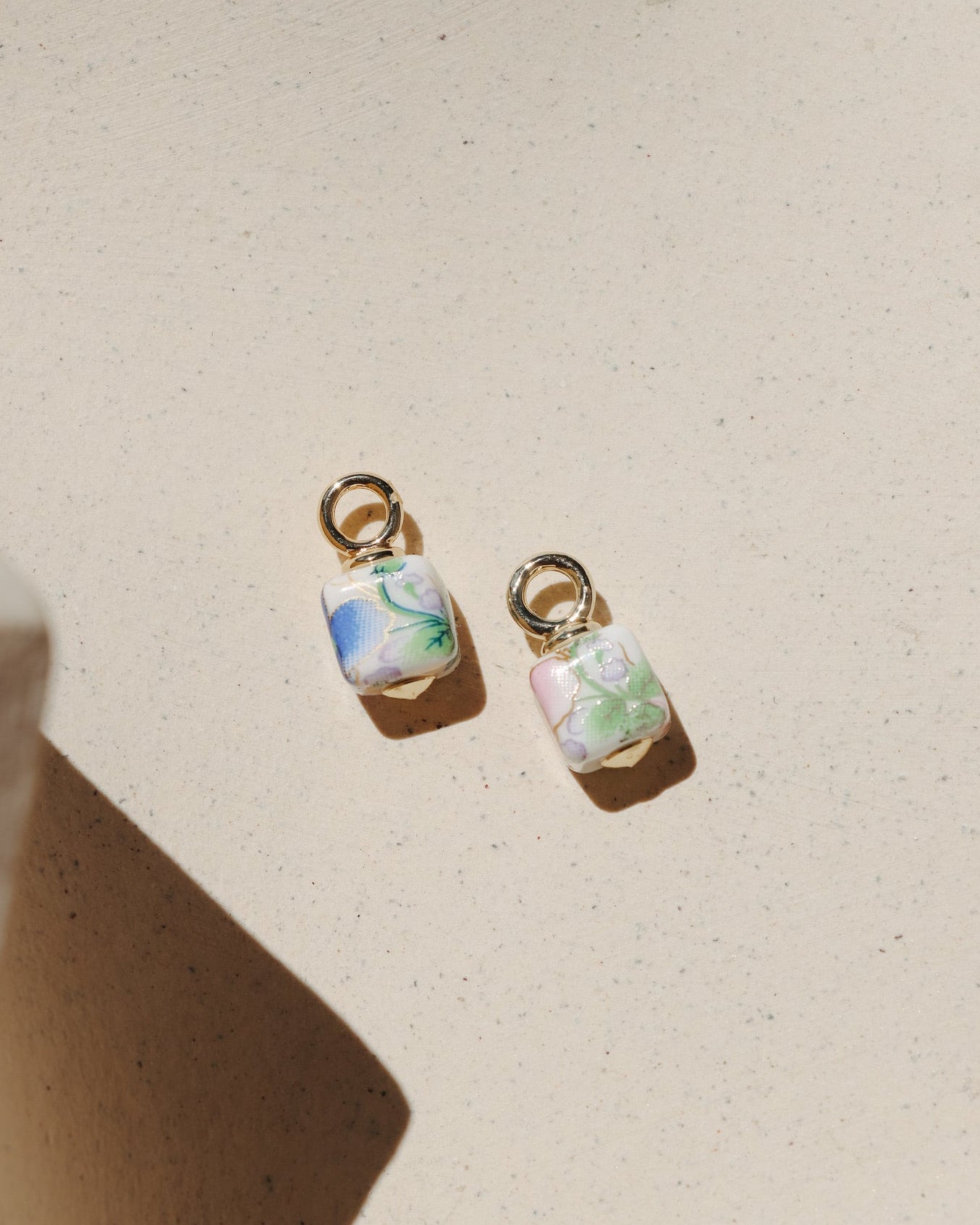 Floral ceramic cube charm with pastel vintage-inspired flowers and gold loop.