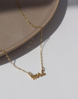 14k gold fill  Mrs.Necklace laid on a white jewelry dish in the sunlight. This is perfect to gift any bride to be in your life.
