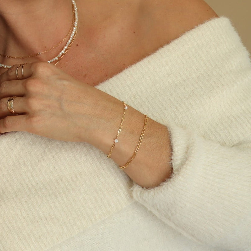 Woman wearing a white off-shoulder top against a beige background