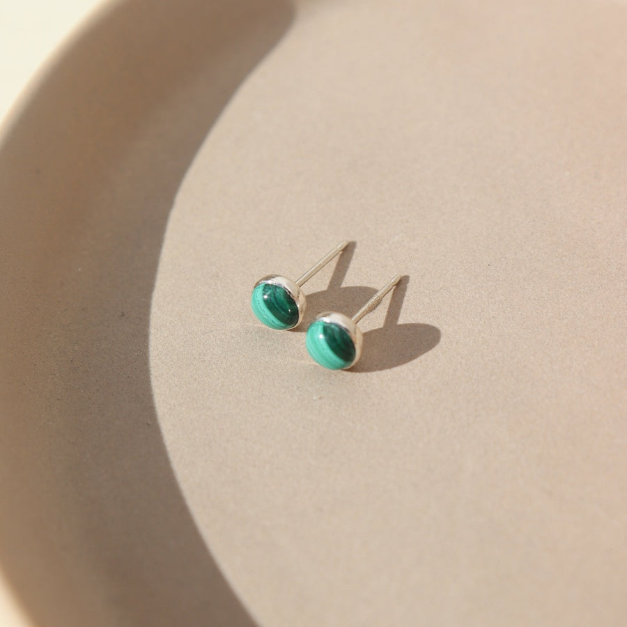small stud sterling silver earrings with malachite stone photographed on a ceramic dish | handmade by Token Jewelry in Eau Claire Wisconsin