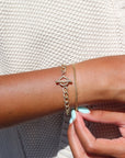 Model wearing 14k gold fill Alexandra Toggle Bracelet in the sunlight. This bracelet features the Alexandra chai with the toggle link to connect it together.