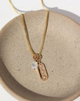 14k gold fill Orion Necklace laid on a tan plate in the sunlight