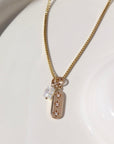 14k gold fill Orion Necklace laid on a white plate in the sunlight