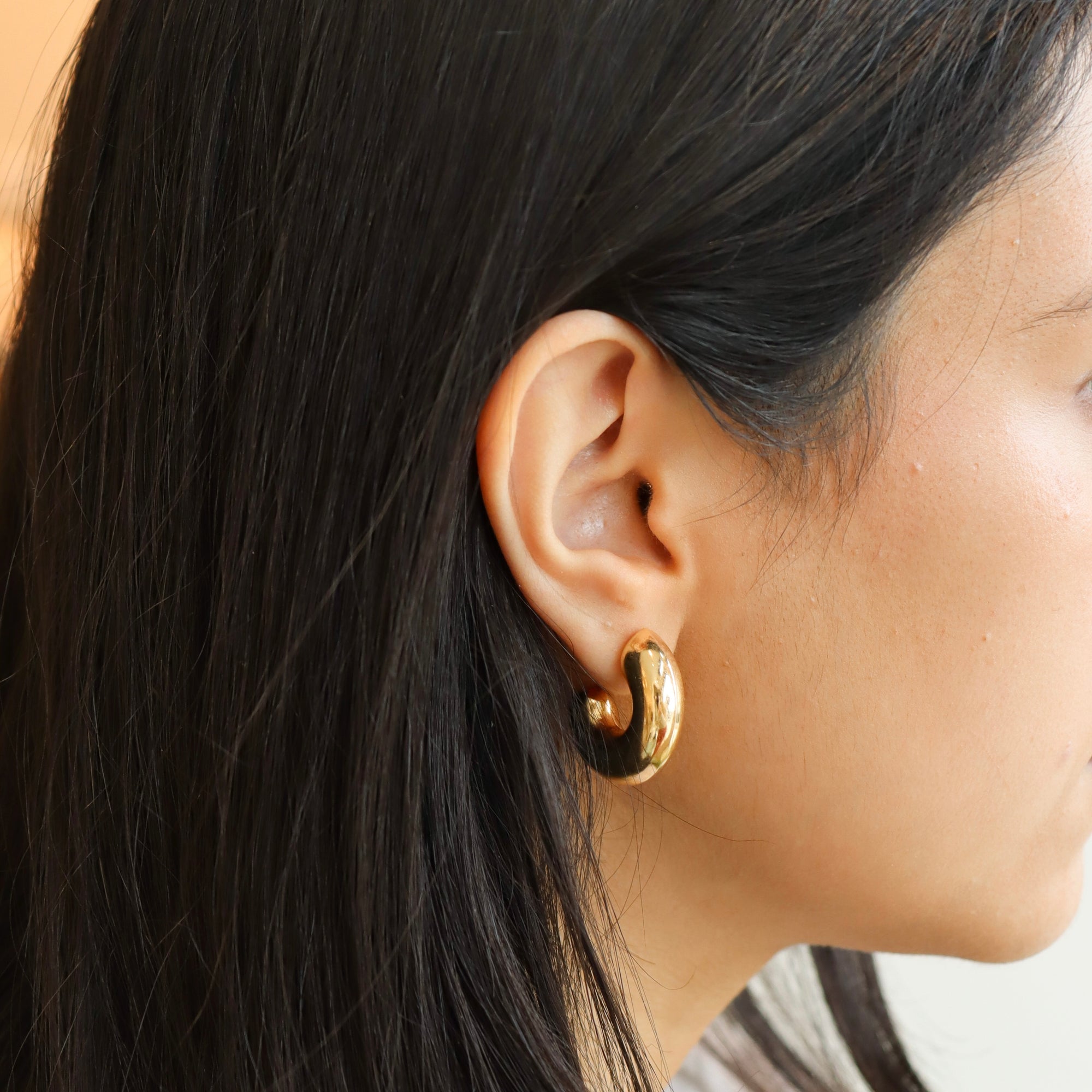 model wearing 14k gold fill chunky hoop studs. 