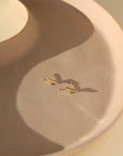 small 14k gold fill lightning bolt stud earrings, on a sunlit ceramic dish