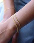 Model wearing 14k gold fill la mer bracelets