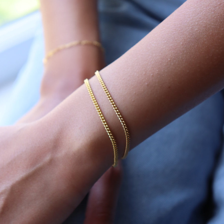 Model wearing 14k gold fill la mer bracelets