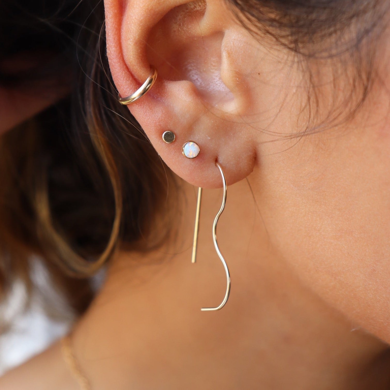 model wearing 14k gold fill bubble slides paired with other earrings