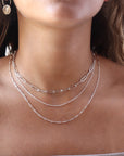 Model wearing 925 sterling silver Gemma chain paired with other chains