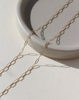 14k solid gold delicate link chain, photographed on a ceramic dish