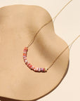 Necklace with colorful beads on a beige dish 