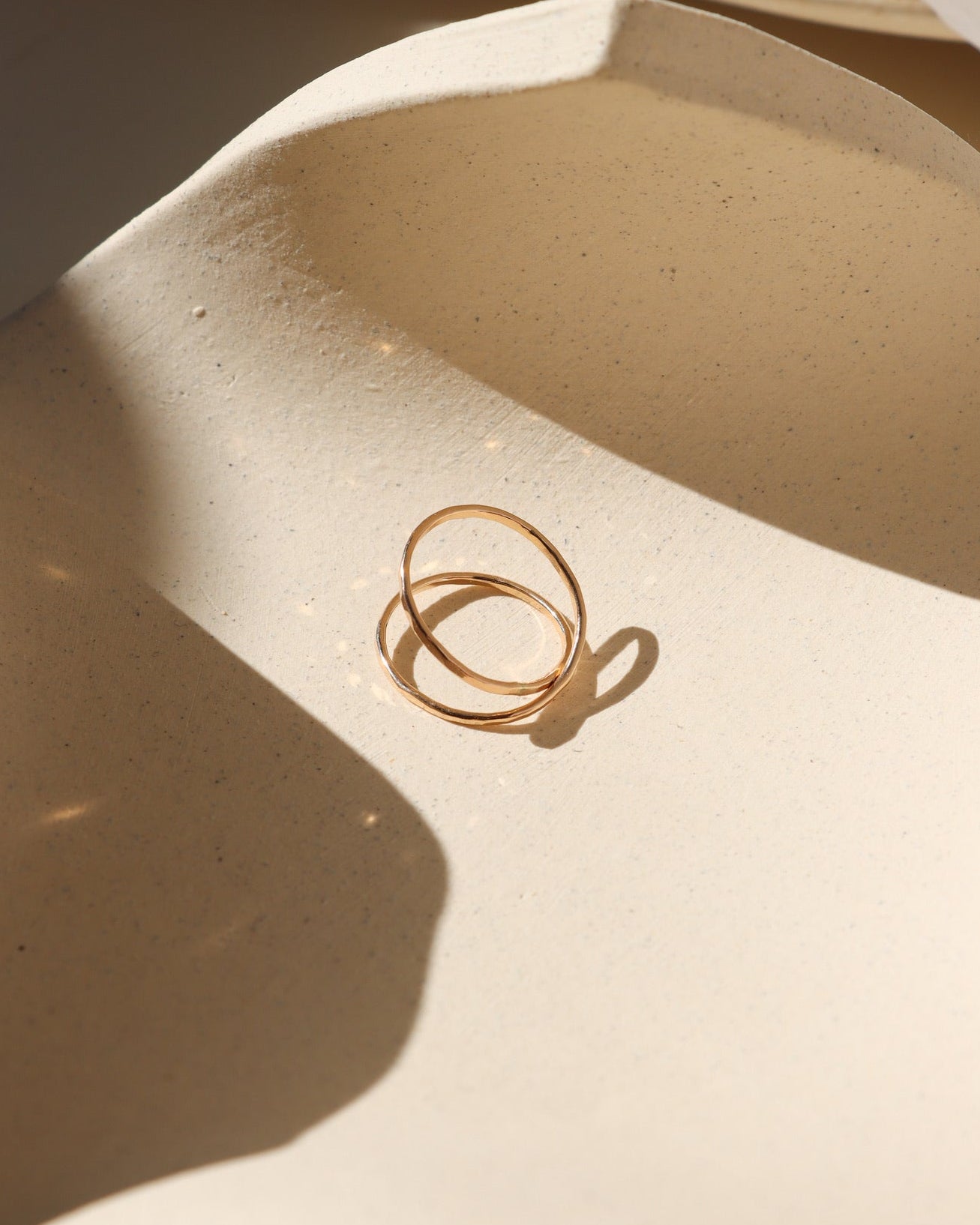 14k gold fill infinity ring laid on dish in the sunlight