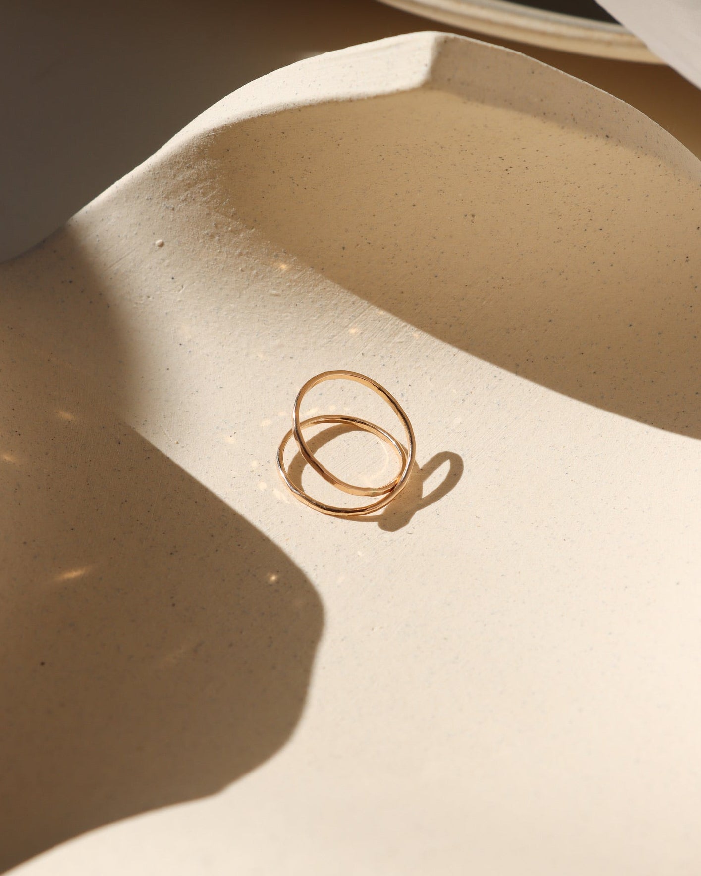 14k gold fill infinity ring laid on dish in the sunlight