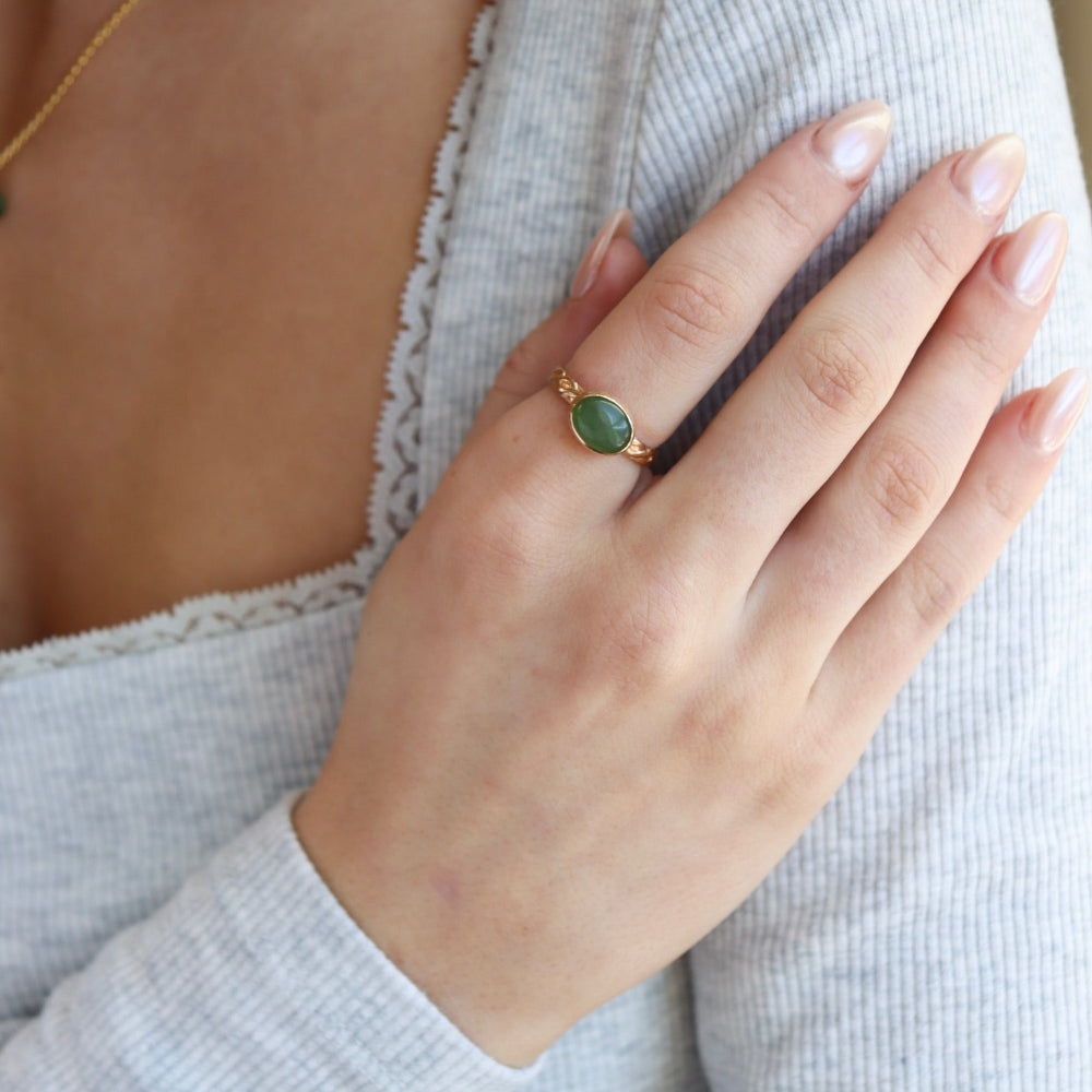 Model is wearing a 14k gold fill entwined band with a 8x10 jade gemstone in a gold bezel. 