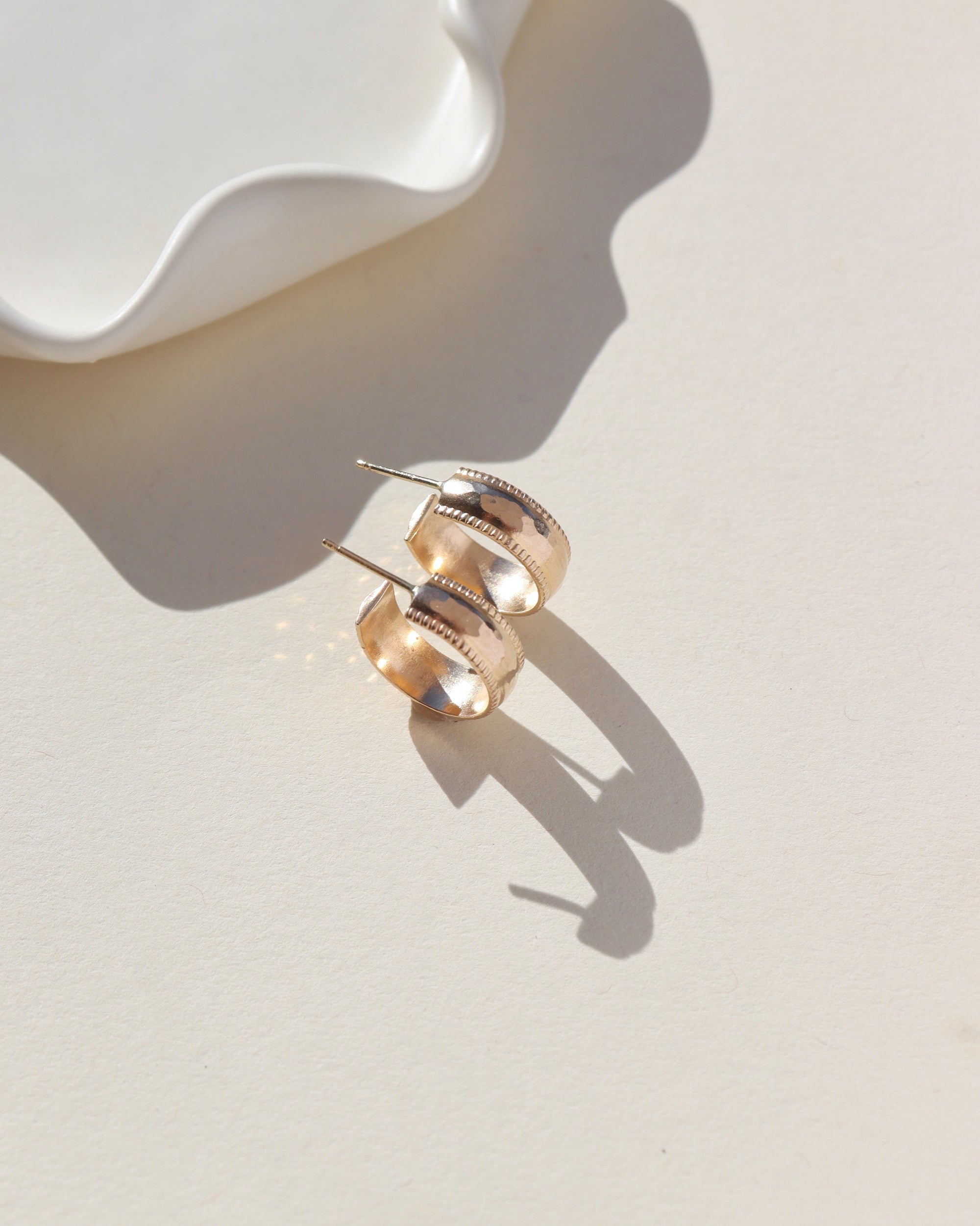 14k gold fill hammered textured stud hoop earrings on a light background