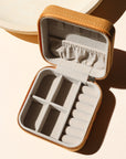 square travel jewelry case opened on a light background