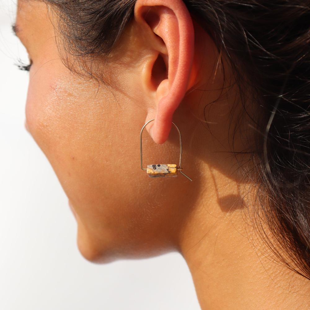 model wearing sterling silver arch shaped earrings with leopard jasper gemstones 