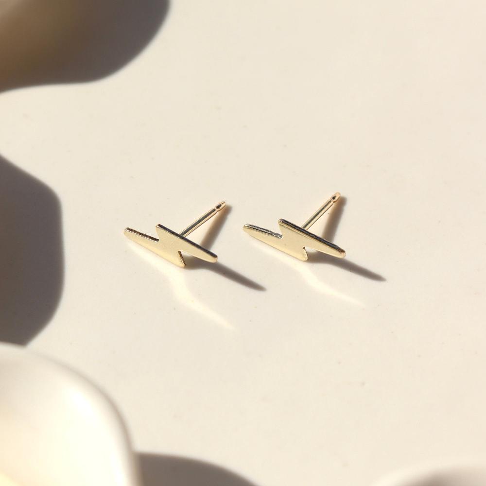 small 14k gold fill lightning bolt stud earrings, on a sunlit ceramic dish