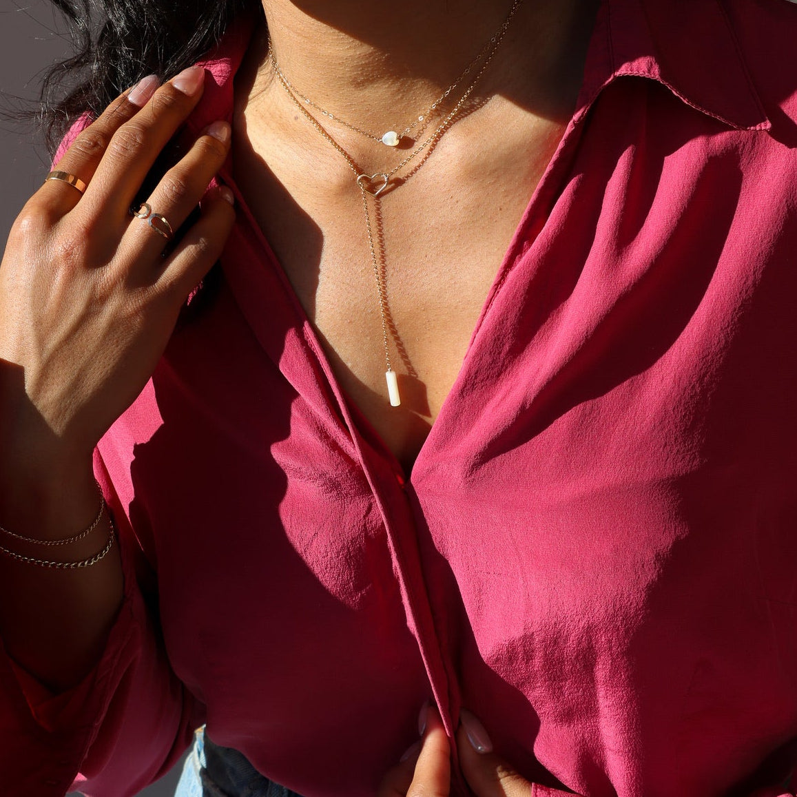 model wearing mother of pearl heart bead on 14k gold fill chain layered with other valentines day 14k gold fill necklace