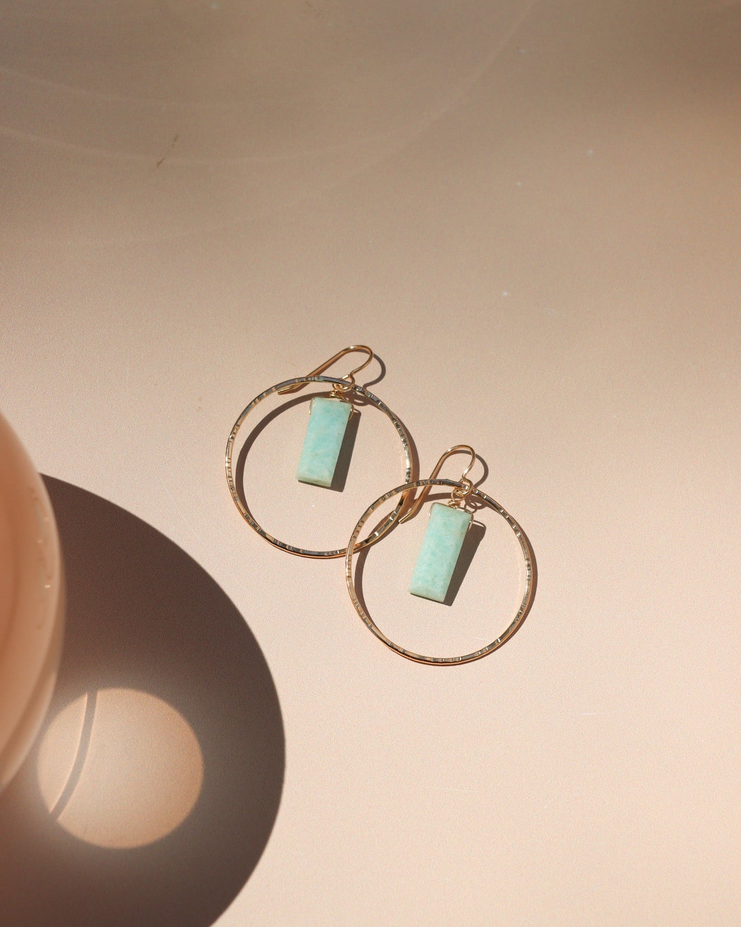 14k gold fill hammered round components with rectangle amazonite stones on a french ear wire on a light dish