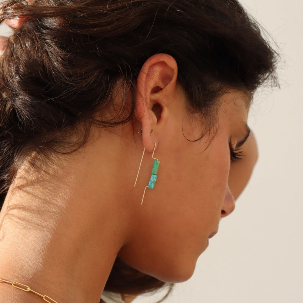 Model wearing 14k gold fill threaders with two turquoise tube shaped gemstones