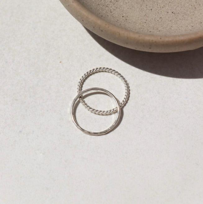 sterling silver hammered ring with a sterling silver spiral band ring on a light background