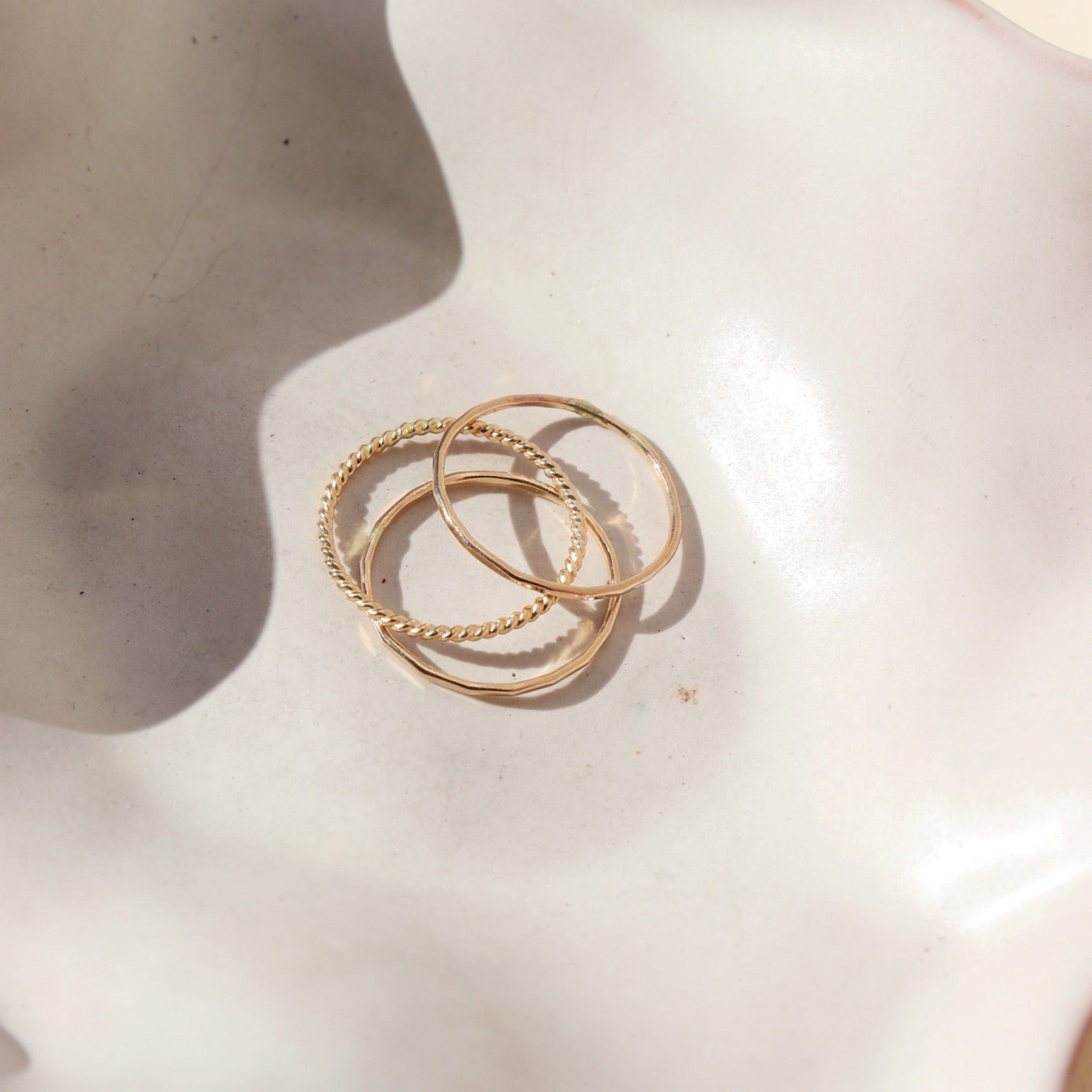 three 14k gold fill rings on a light dish