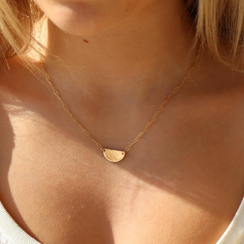 model wearing 14k gold fill half moon necklace. This necklace features a half circle hammered in the middle each side connected by the cosset chain.