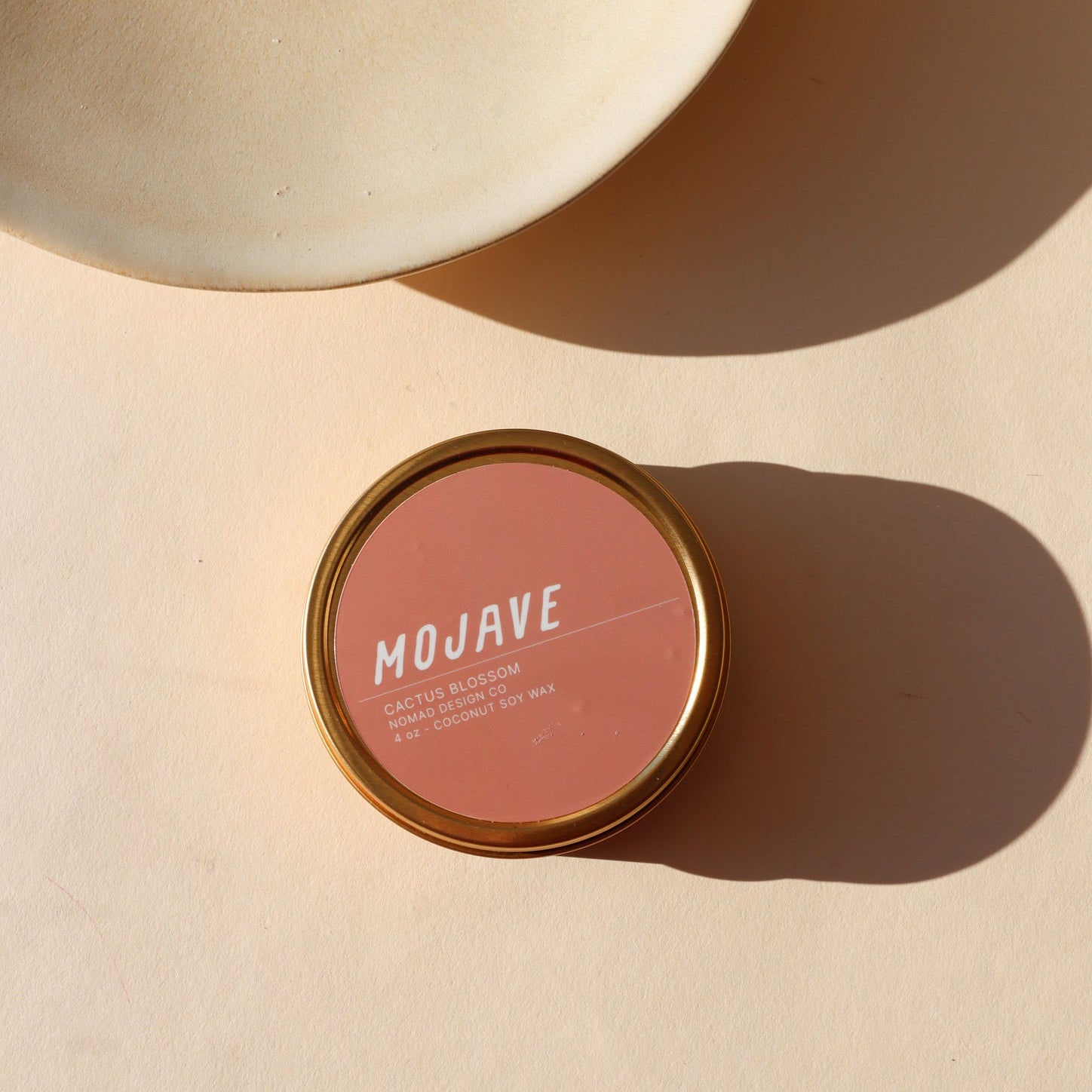 mojave scented candle in a tin displayed in the sunlight