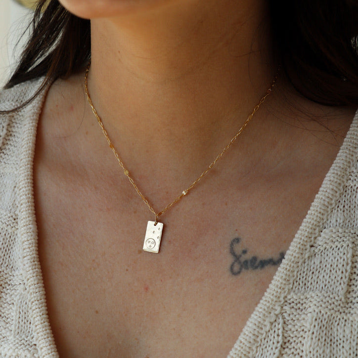 model wearing 14k gold fill delicate chain necklace with hand stamped pendant with moon and stars