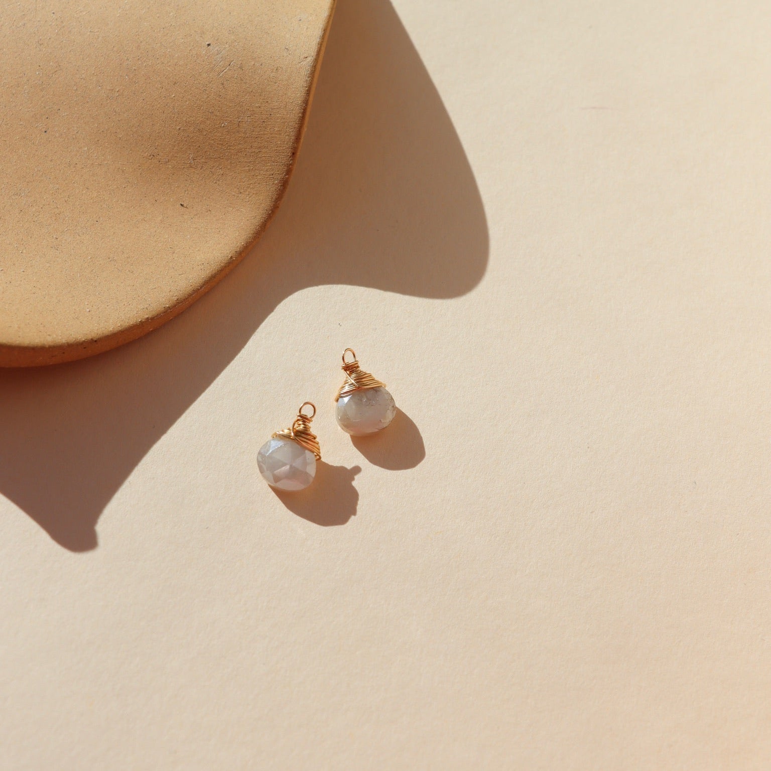  Iridescent moonstone charms with soft, shimmering hues.