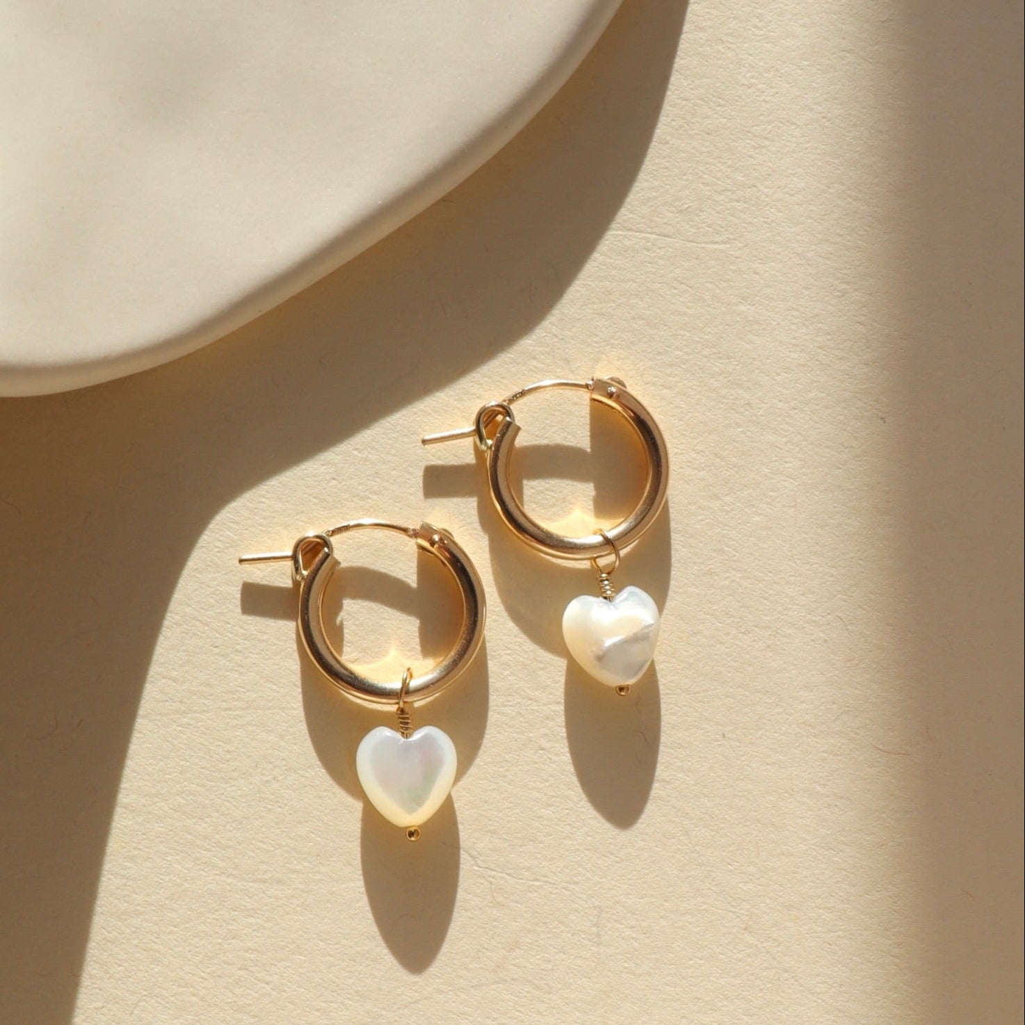 14k gold fill Classic Hoops featuring a dainty Mother of Pearl heart-shaped charm on each 15mm hoop