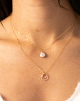 Delicate gold necklace featuring a shimmering oval moonstone pendant with iridescent hues.