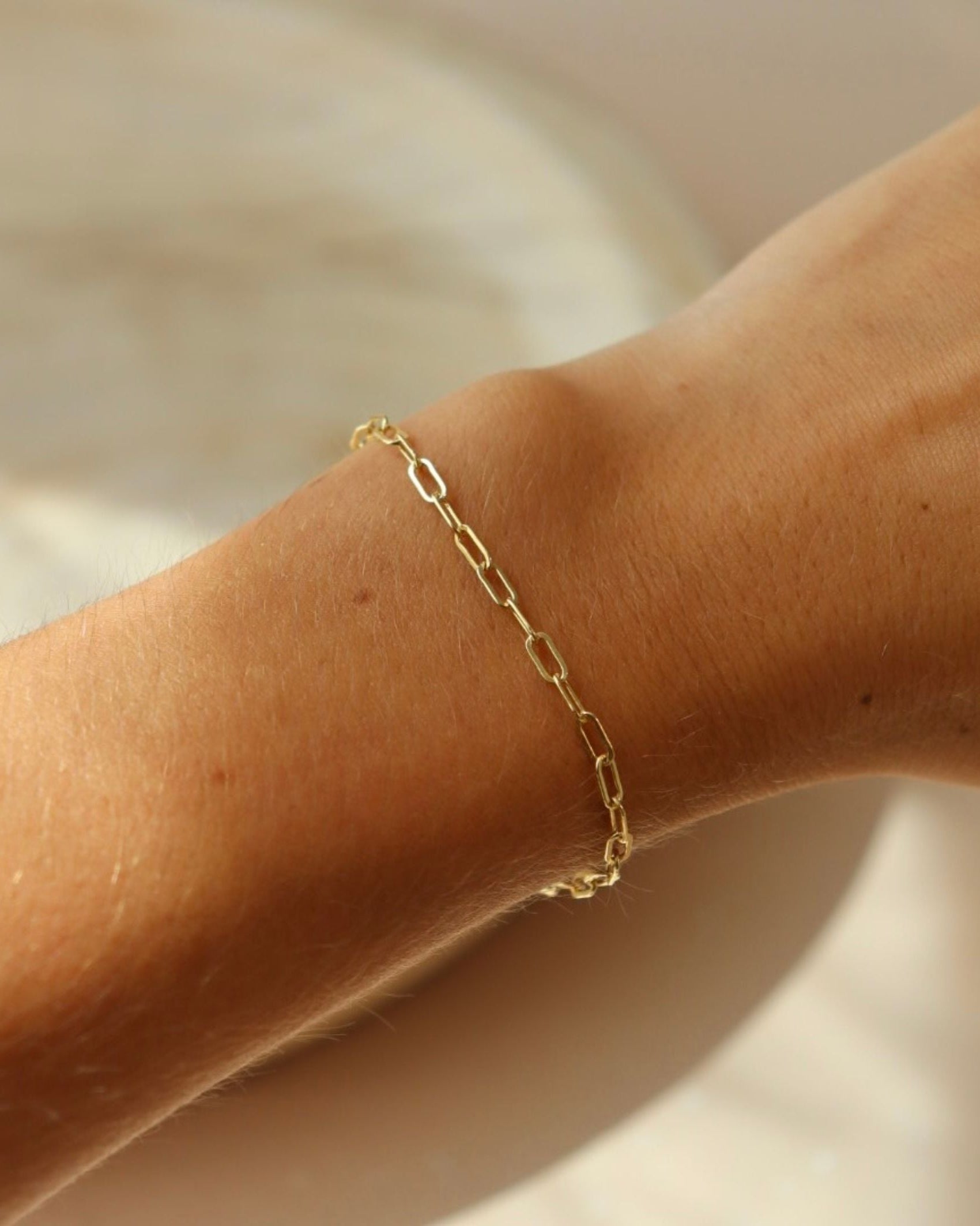 model wearing 14k gold fill paperclip chain bracelet