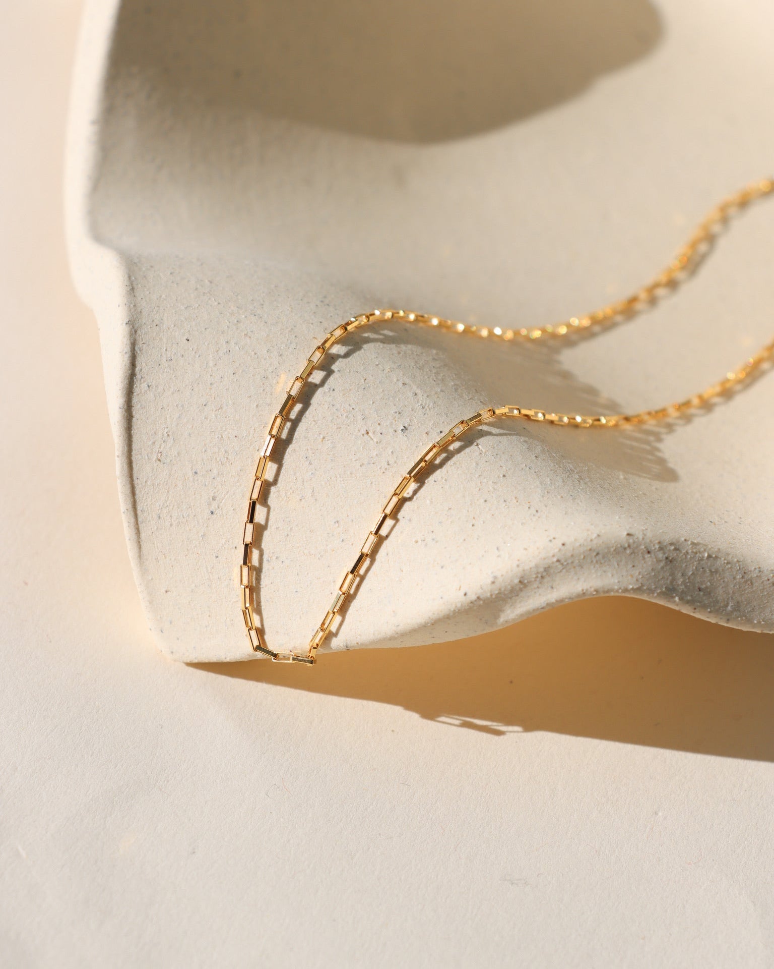 14k gold fill chain necklace on a light dish 