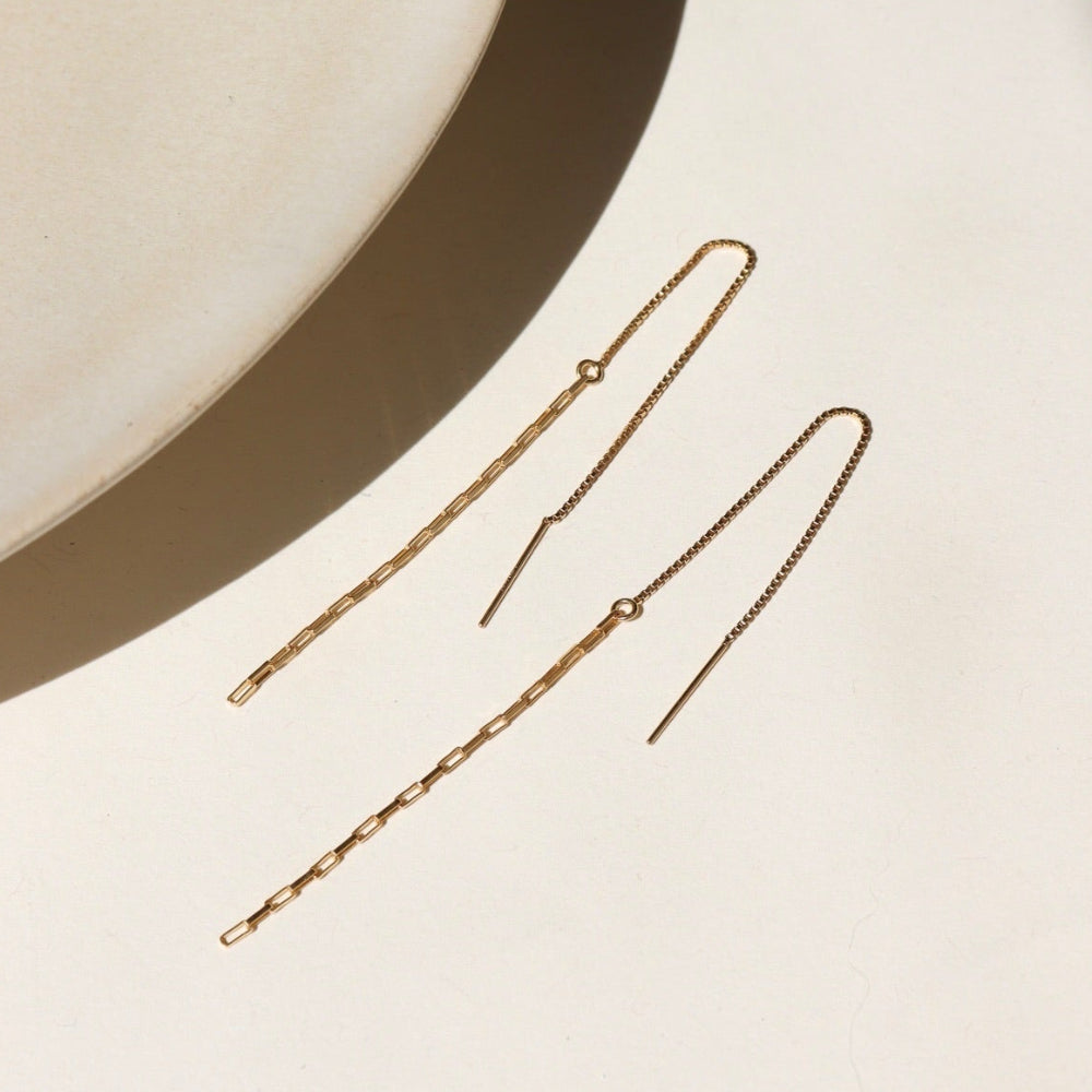14k gold fill threader earring, displayed on a cream backdrop in the sunlight 