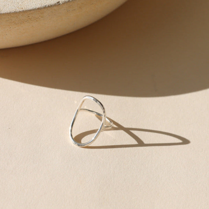 sterling silver hammered oval ring on a light background