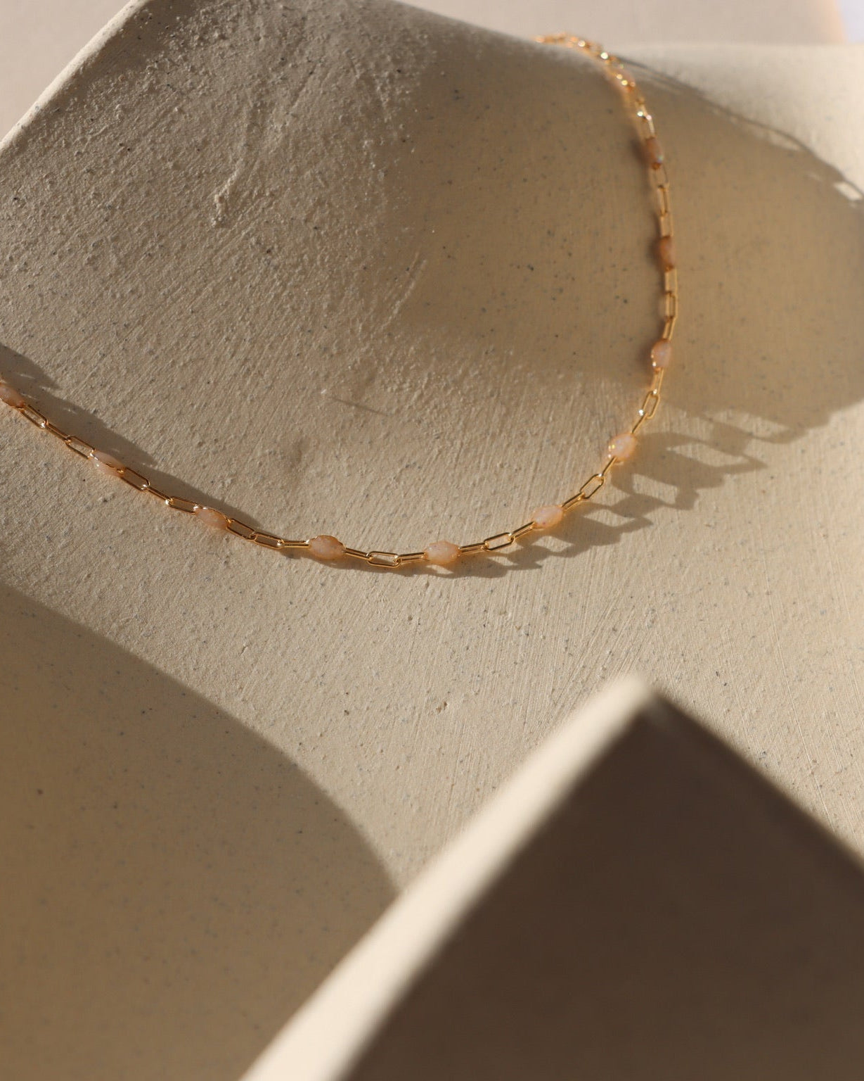 Opal Enamel chain links with 14k gold filled delicate paperclip chain on a light background.