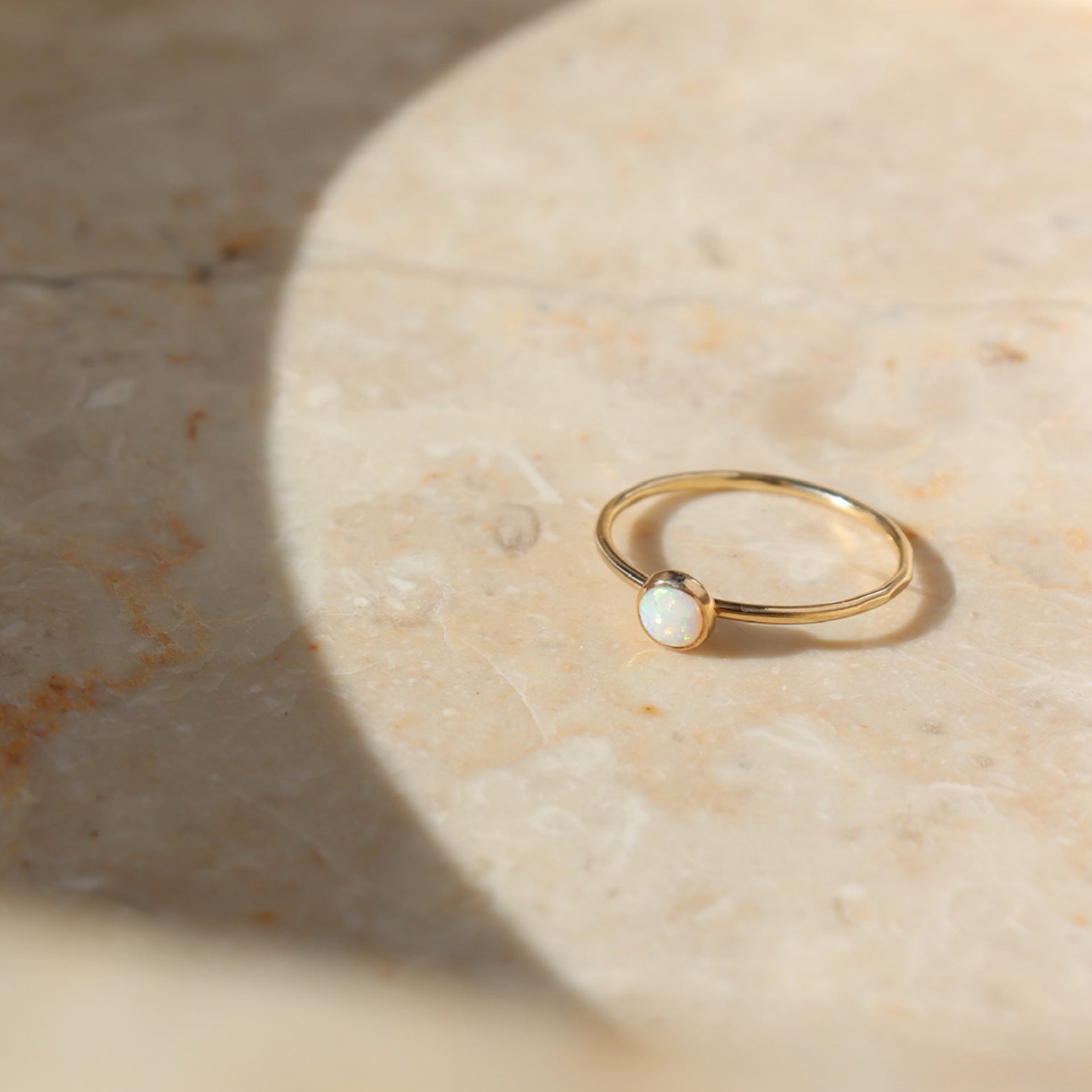 14k gold fill bezel ring setting with smooth 4mm opal stone on a light background