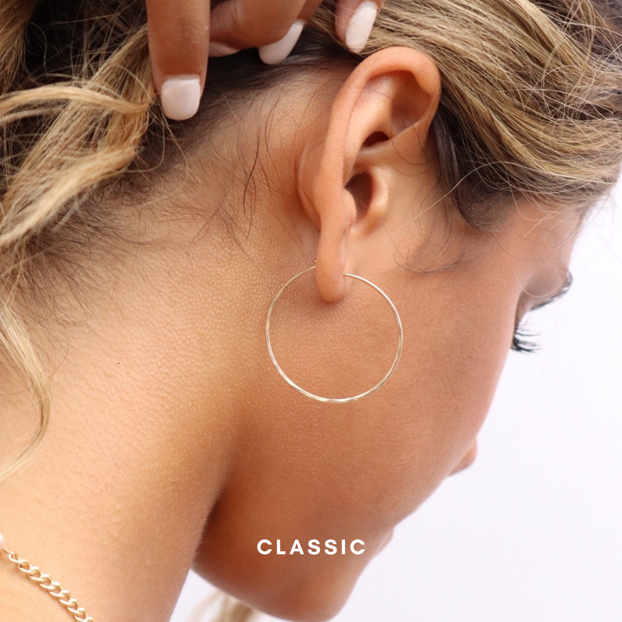 model wearing sterling silver hand made hammered hoop earrings 