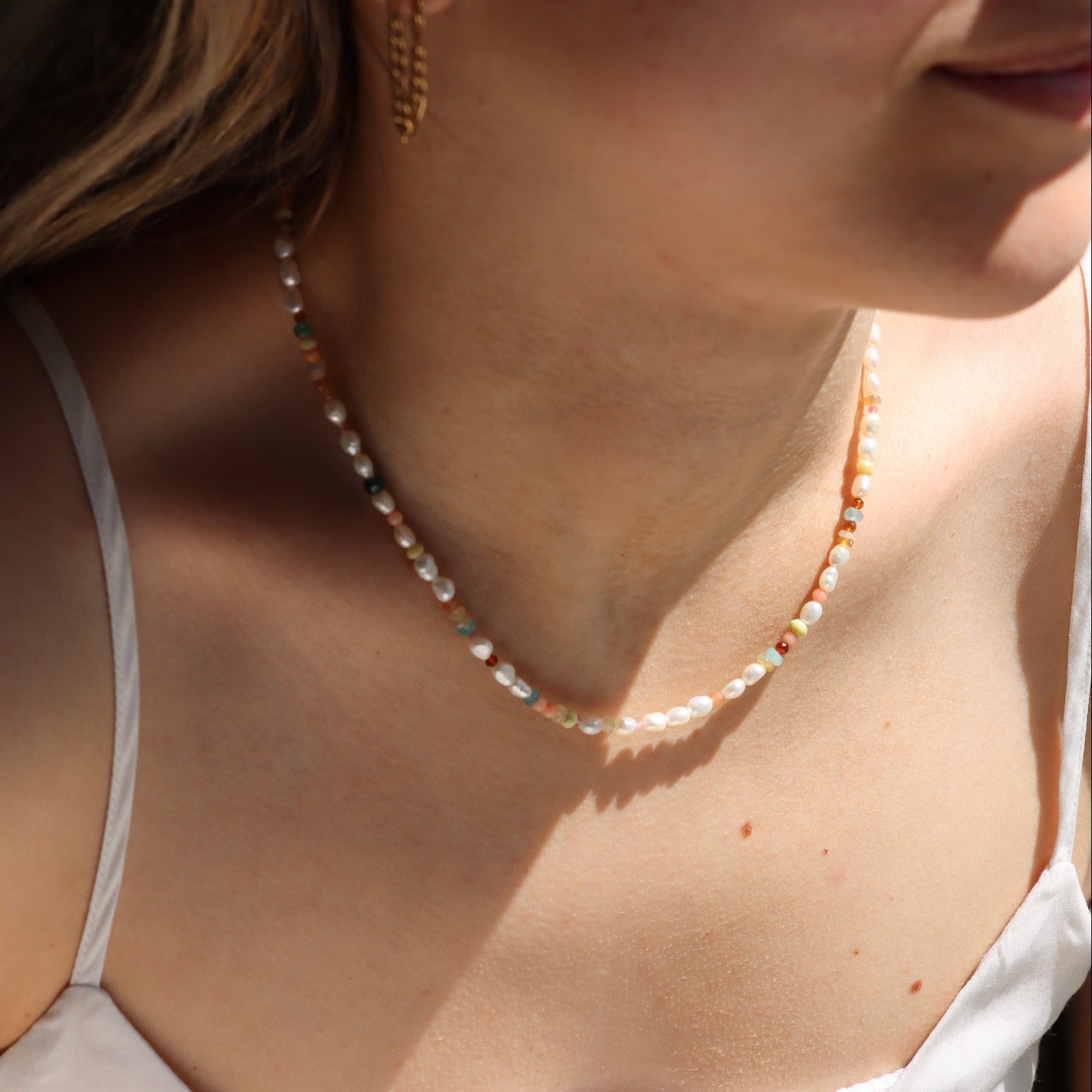 model wearing gemstone and pearl beaded neckalce