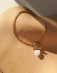 Bracelet by Token Jewelry - a 14k gold fill La Mer Chain with a toggle and a mother of pearl heart charm. This bracelet features a gold curb chain with a toggle clasp opening with a mother of pearl heart at the end. 