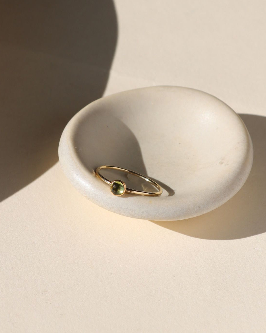 hammered 14k gold fill band ring set with light peridot stone in the sunlight