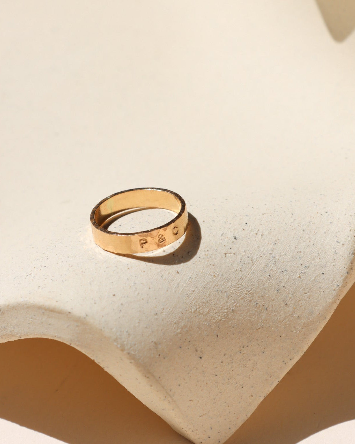 14k gold fill hand stamped band ring on a light dish
