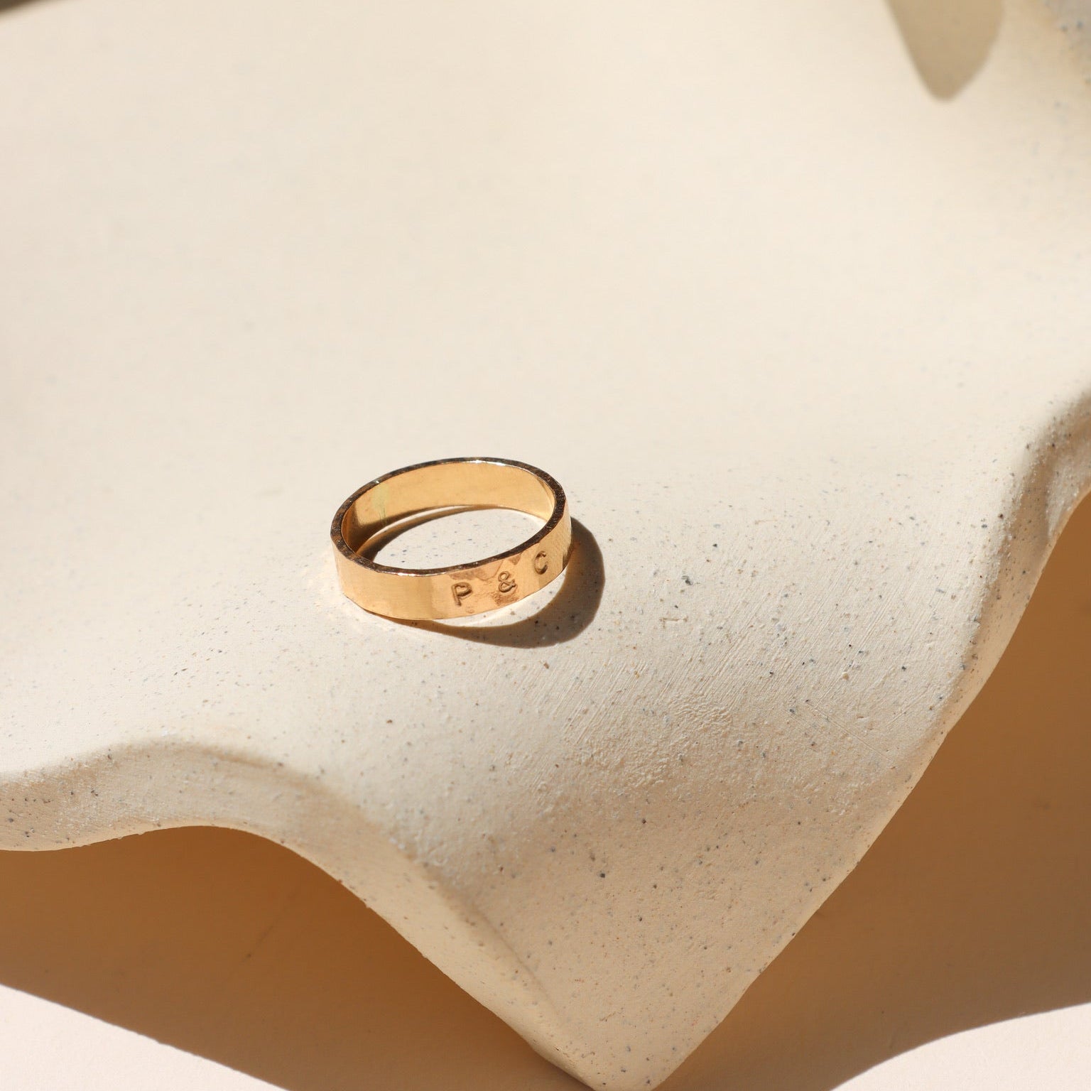 14k gold fill hand stamped band ring on a light dish