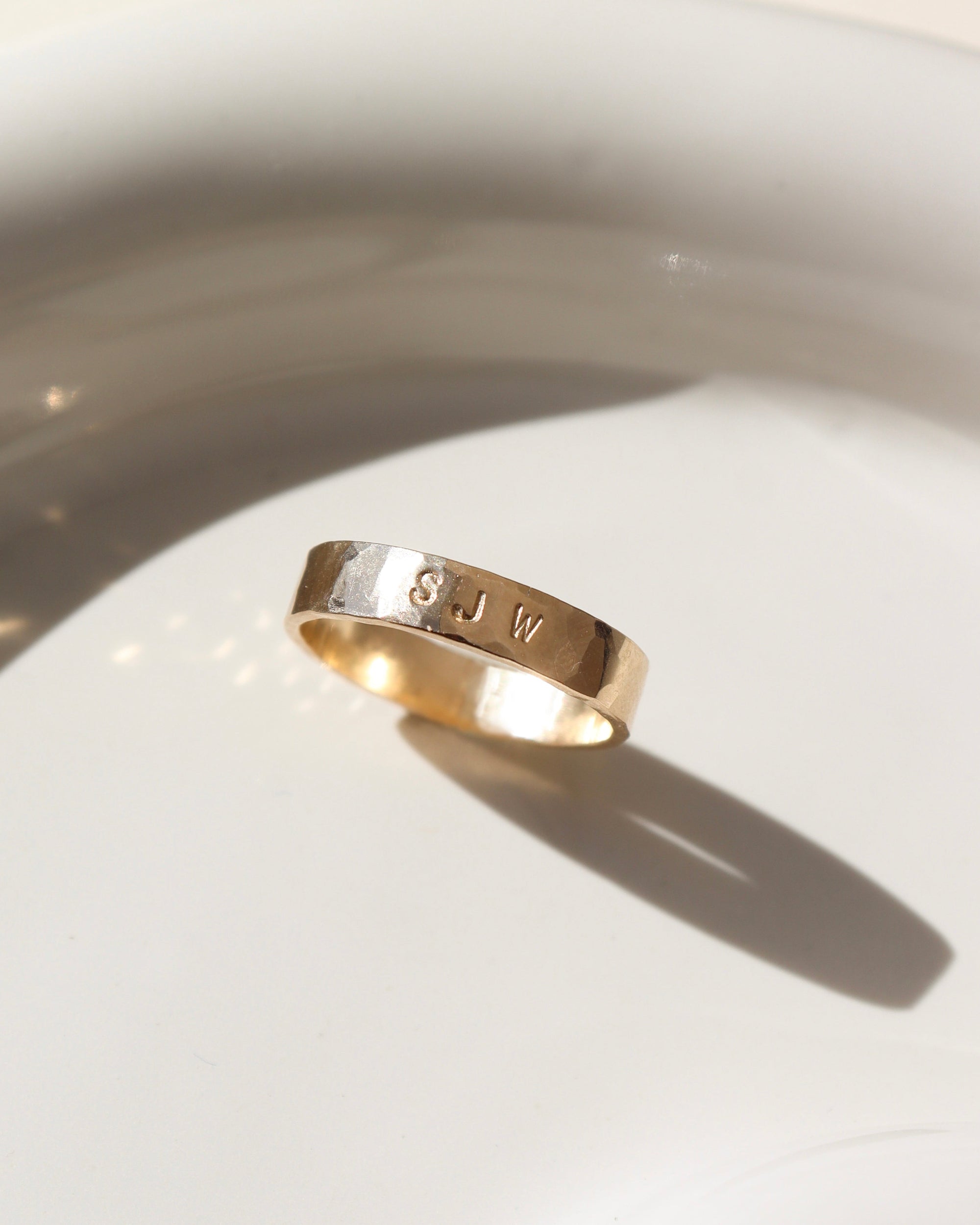 14k gold fill hand stamped cigar band ring on a light dish