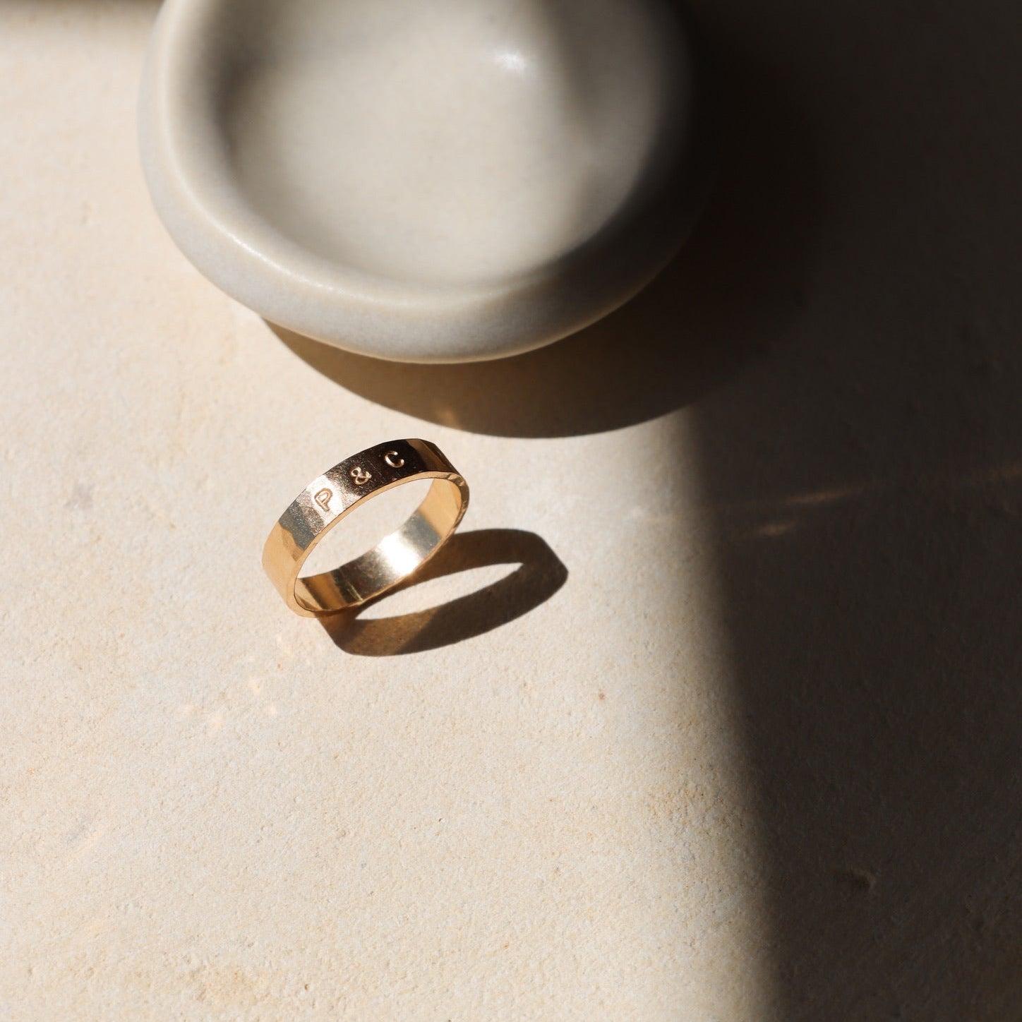 14k gold fill hand stamped and hammered ring on a light surface
