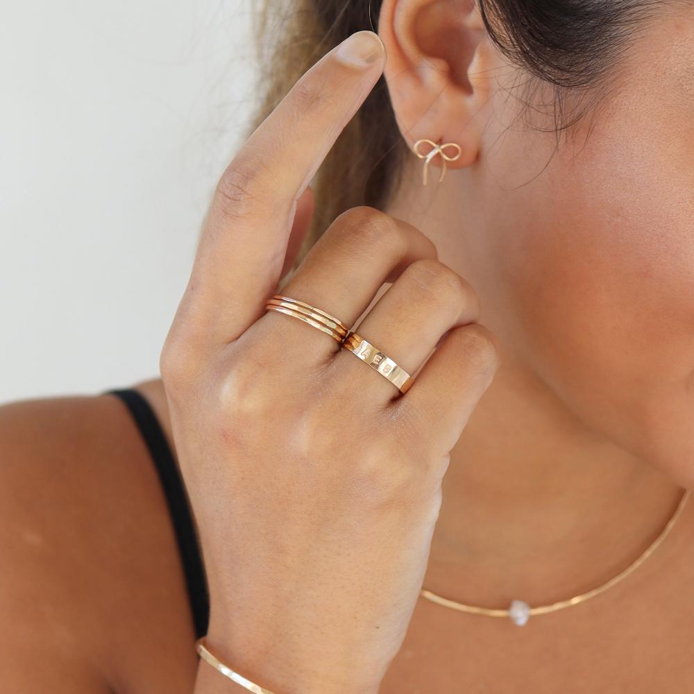 model wearing 14k gold fill hammered rings and a hand stamped cigar band 